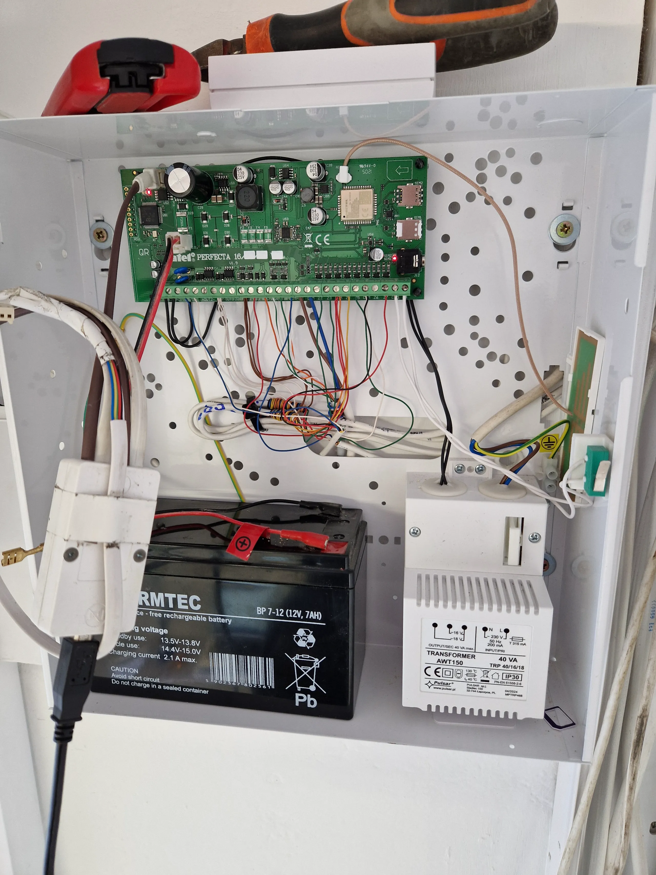 Wnętrze rozdzielnicy elektrycznej z podłączonymi elementami systemu alarmowego