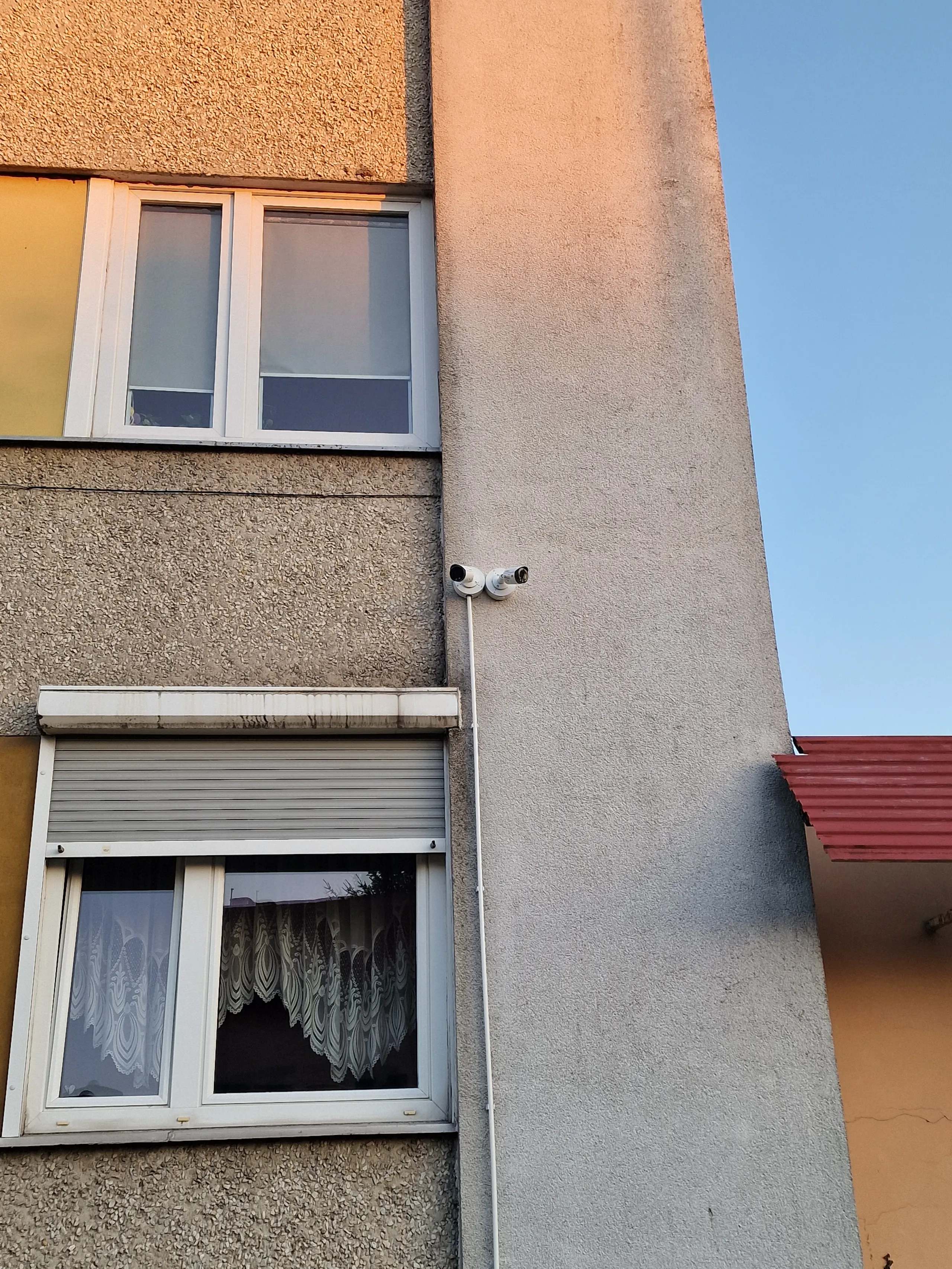 Kamera przemysłowa zamontowana na elewacji budynku, idealna do monitoringu