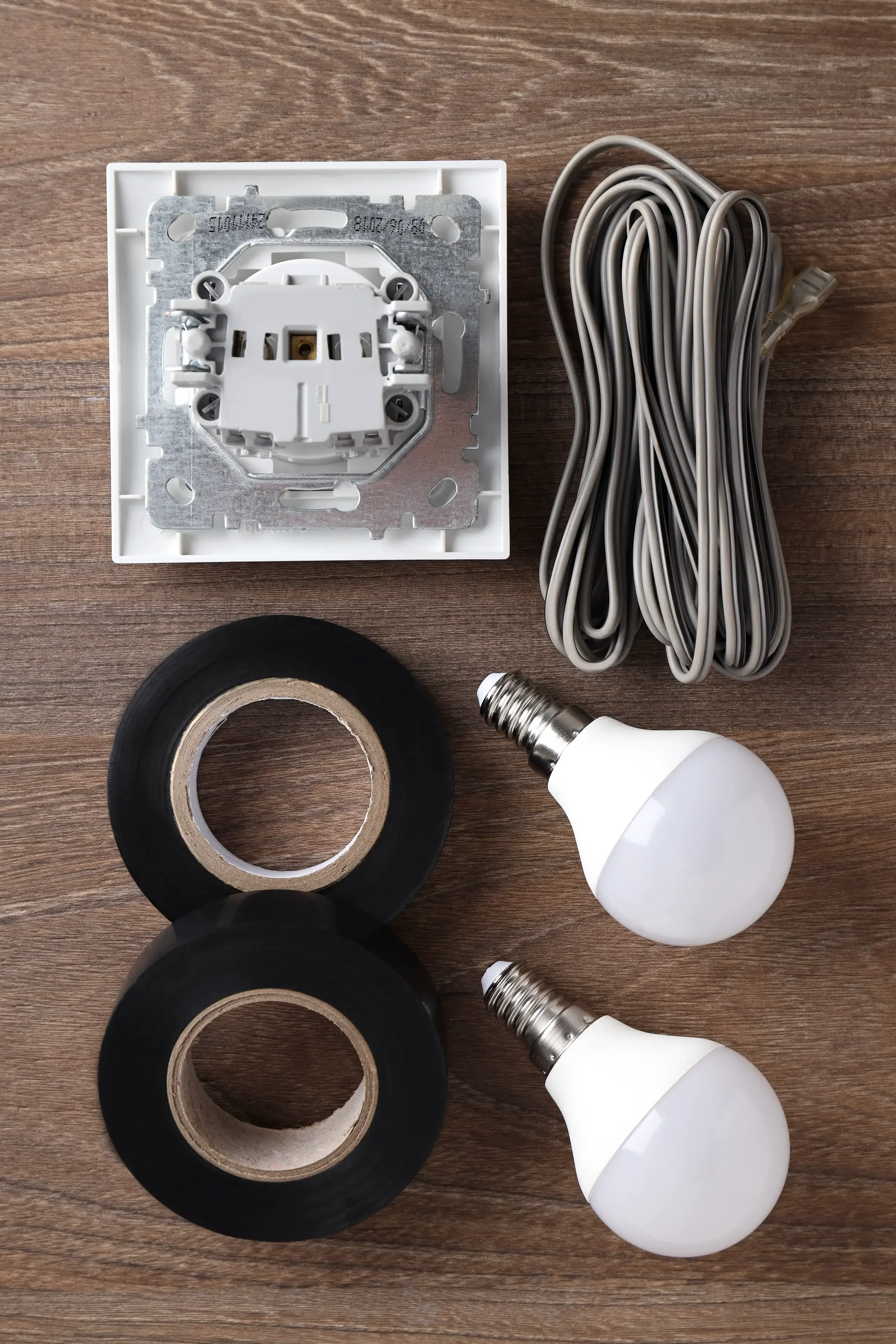 Zestaw akcesoriów elektrycznych: gniazdko, przewód, taśmy izolacyjne i żarówki LED